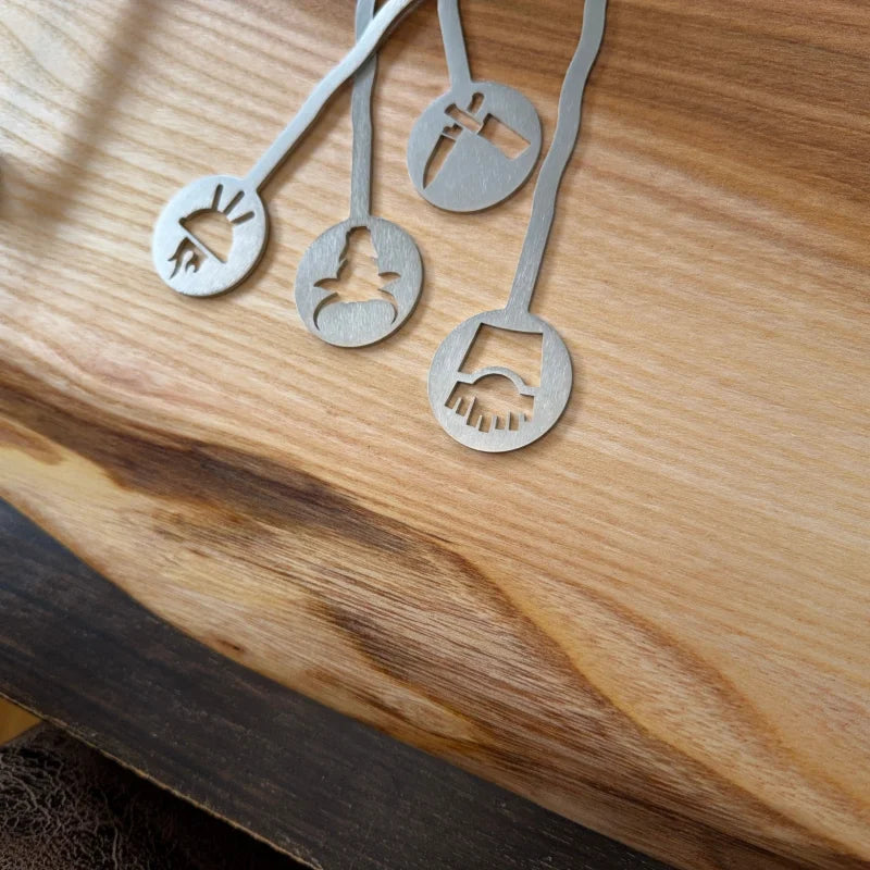 Graue Metallmesslöffel mit tierischen Ausschnitten für dein Holzschneidebrett BBQ