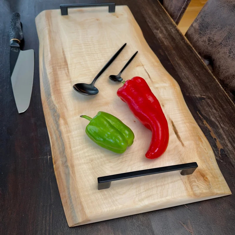 Holz Schneidebrett mit schwarzen Griffen, Löffeln und Paprika, perfekt für jede Küche