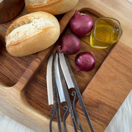 Holzbrett mit Einfräsungen, Brotrollen, Zwiebeln und Olivenöl auf UNIKAT Snackboard ulmenholz